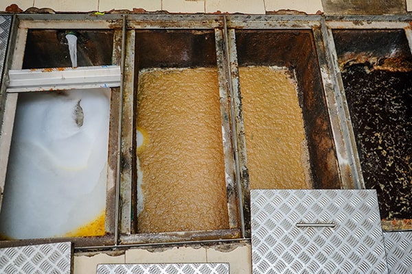 foul odors, slow drainage, and an increase in grease buildup are signs that your grease trap needs maintenance